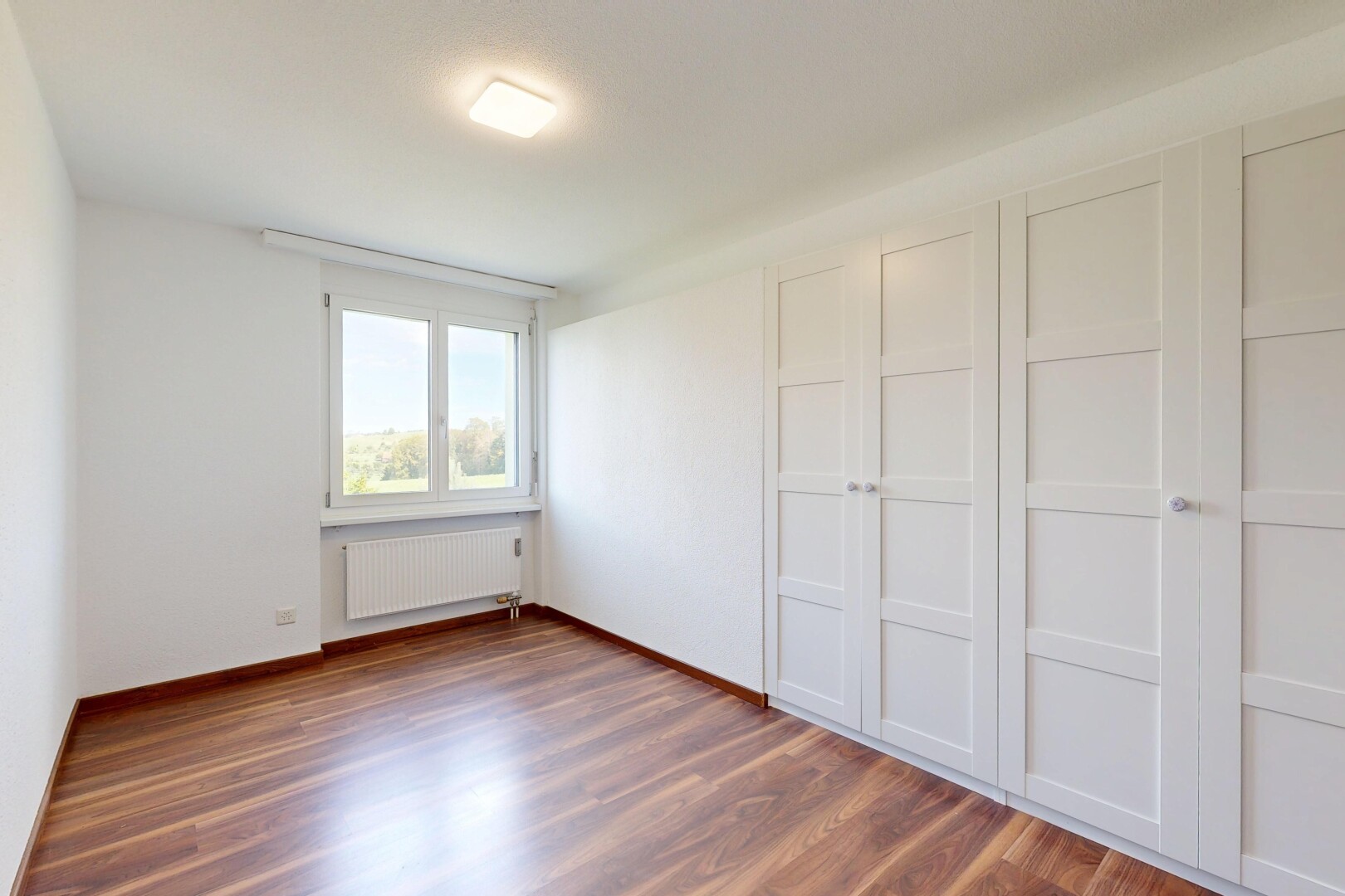 pièce vide avec radiateur, drywall, cloison sèche, wood finish floor, et sol en finition bois