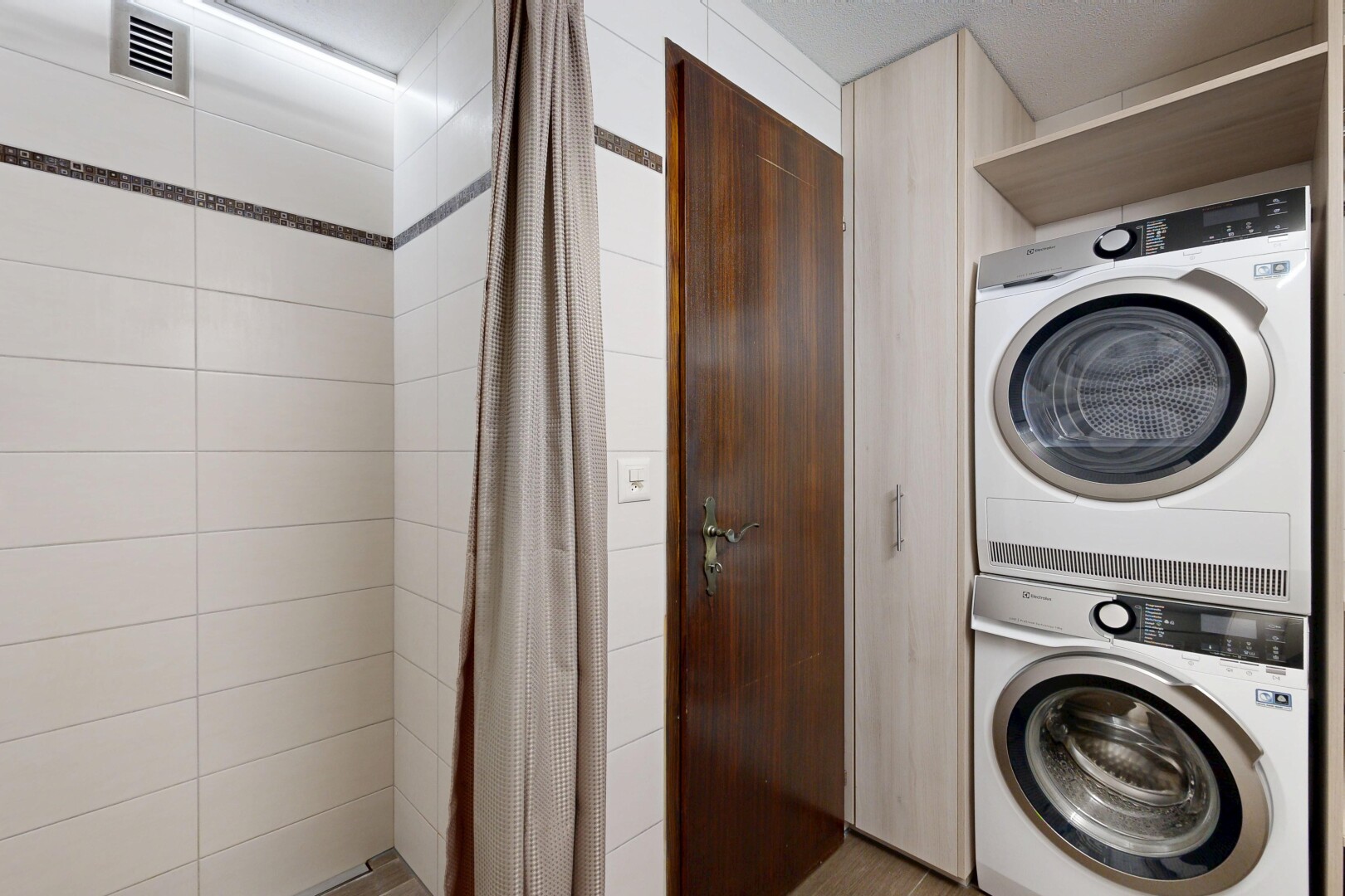 buanderie avec buanderie, lave-linge et sèche-linge superposés, inside property, et ventilation