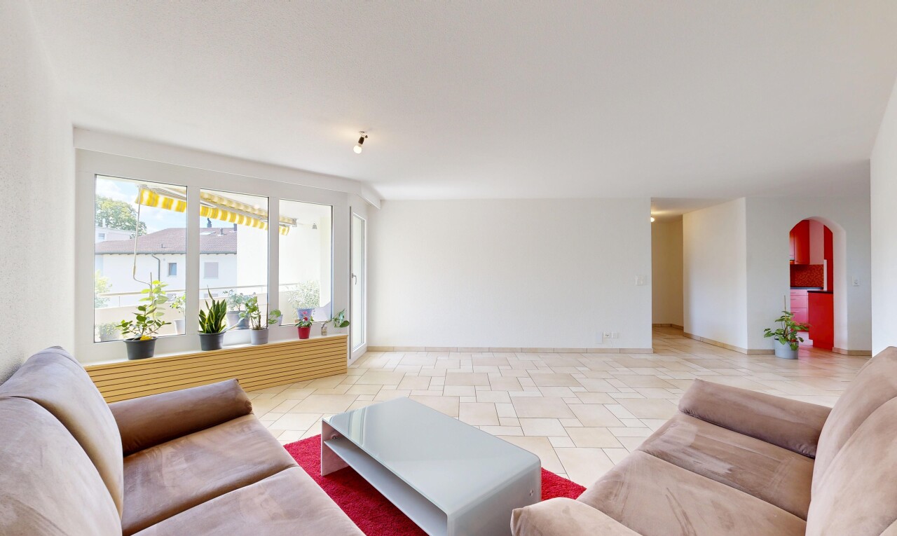 salon avec passages en arc, drywall, cloison sèche, light floor, et inside property