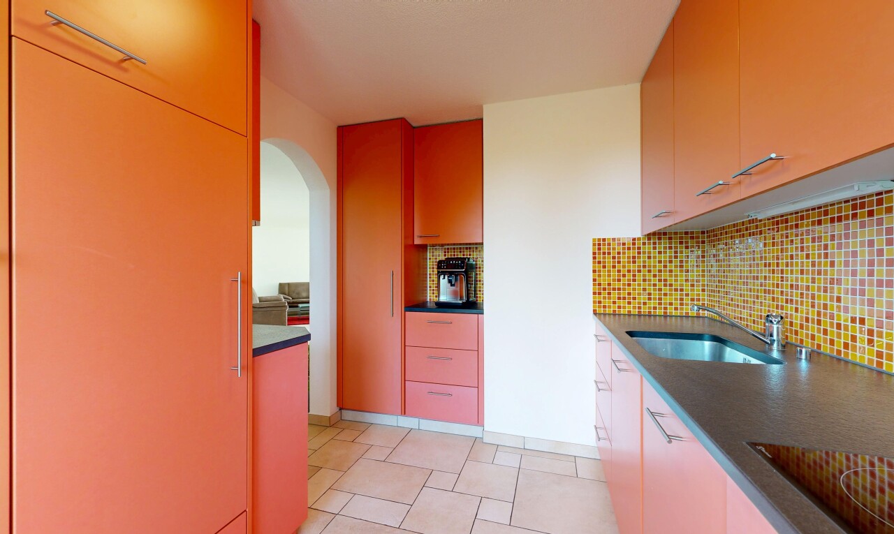 cuisine avec plans de travail, dark countertops, passages en arc, light floor, et évier