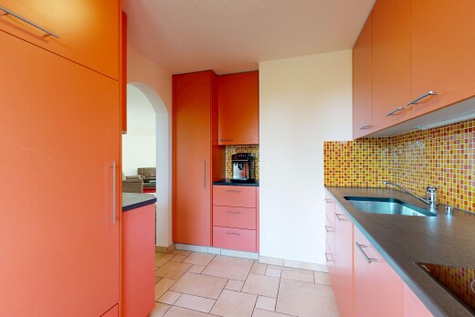 cuisine avec plans de travail, dark countertops, passages en arc, light floor, et évier