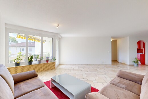 salon avec passages en arc, drywall, cloison sèche, light floor, et inside property