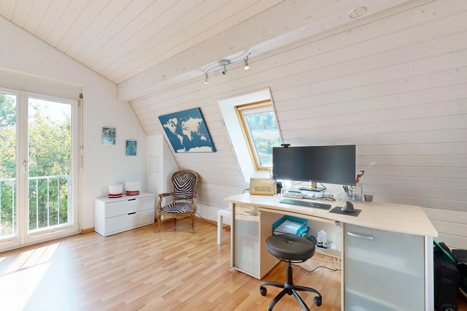 bureau avec plafond voûté, vaulted ceiling, télévision, sol en finition bois, et wood finish floor