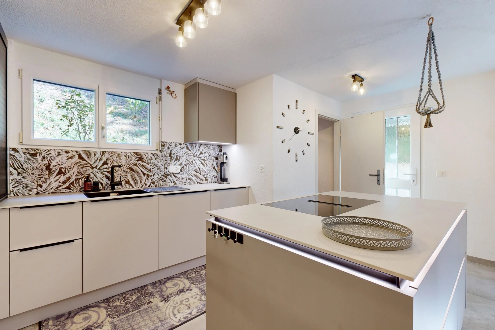 cuisine avec plans de travail, light countertops, îlot de cuisine, kitchen island, et évier
