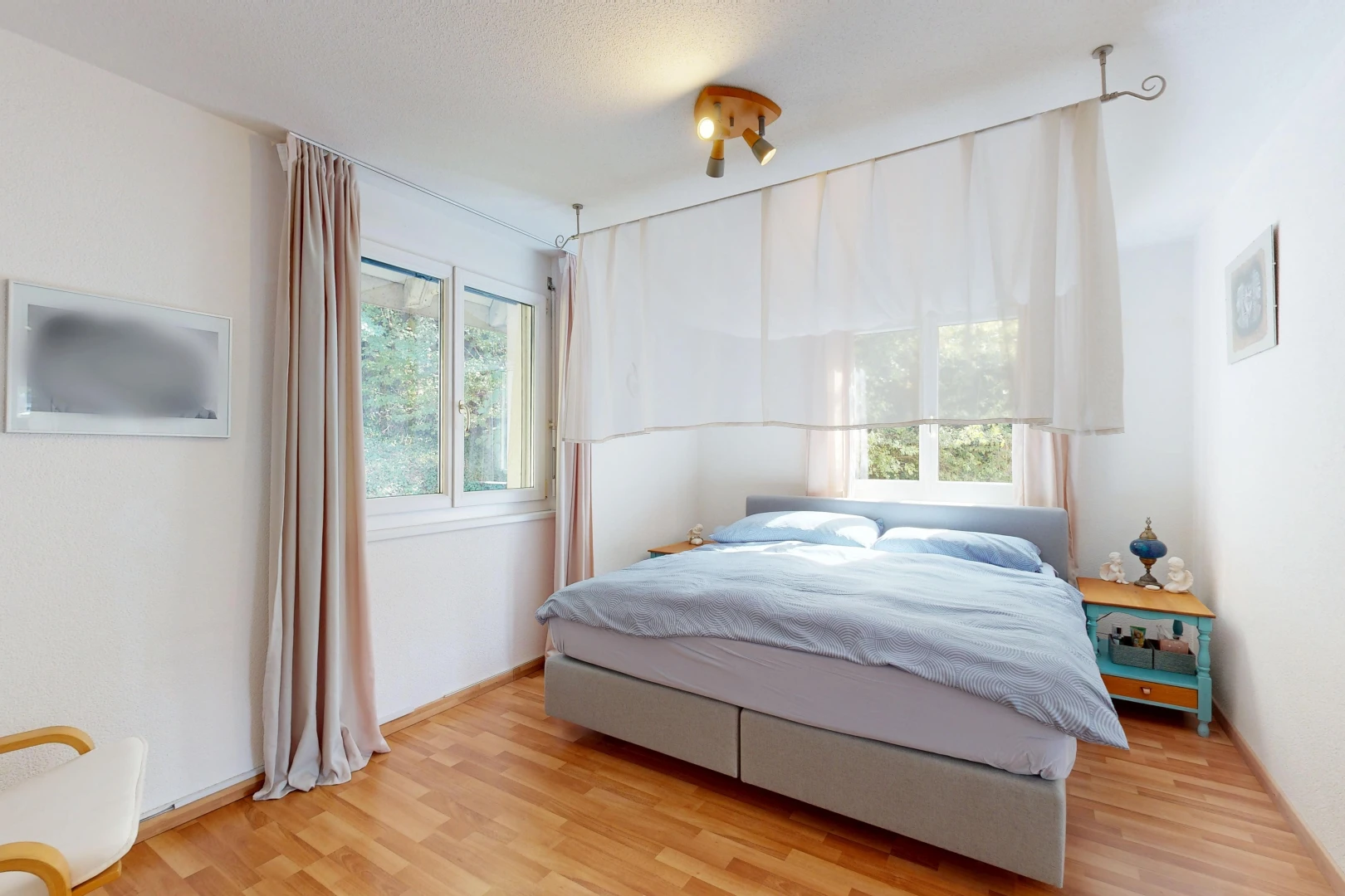 chambre avec cloison sèche, drywall, lumière naturelle, sol en finition bois, et wood finish floor