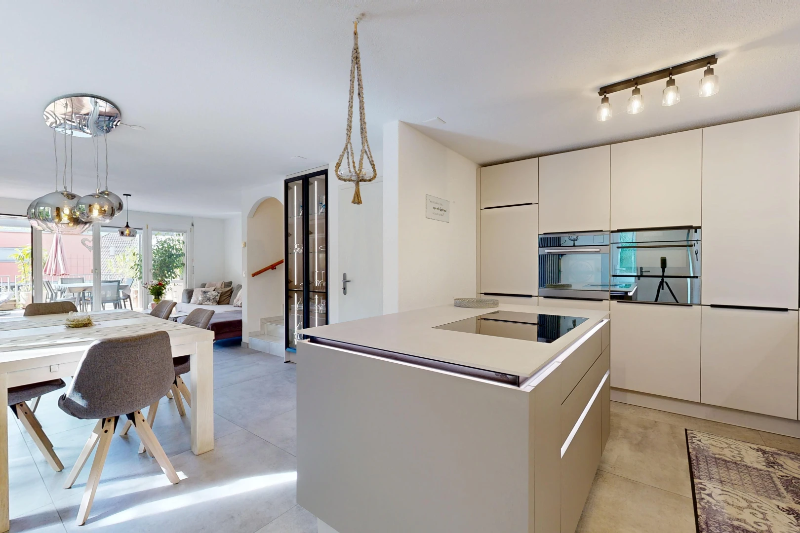 cuisine avec îlot de cuisine, kitchen island, light floor, pendant lighting, et four double