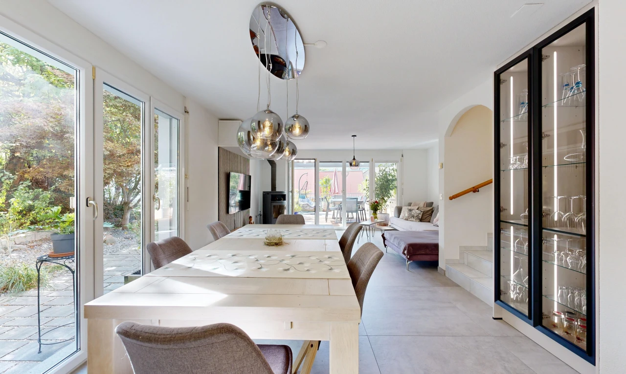 salle à manger avec escaliers, accès à l'extérieur, éclairage suspendu, télévision, et light floor