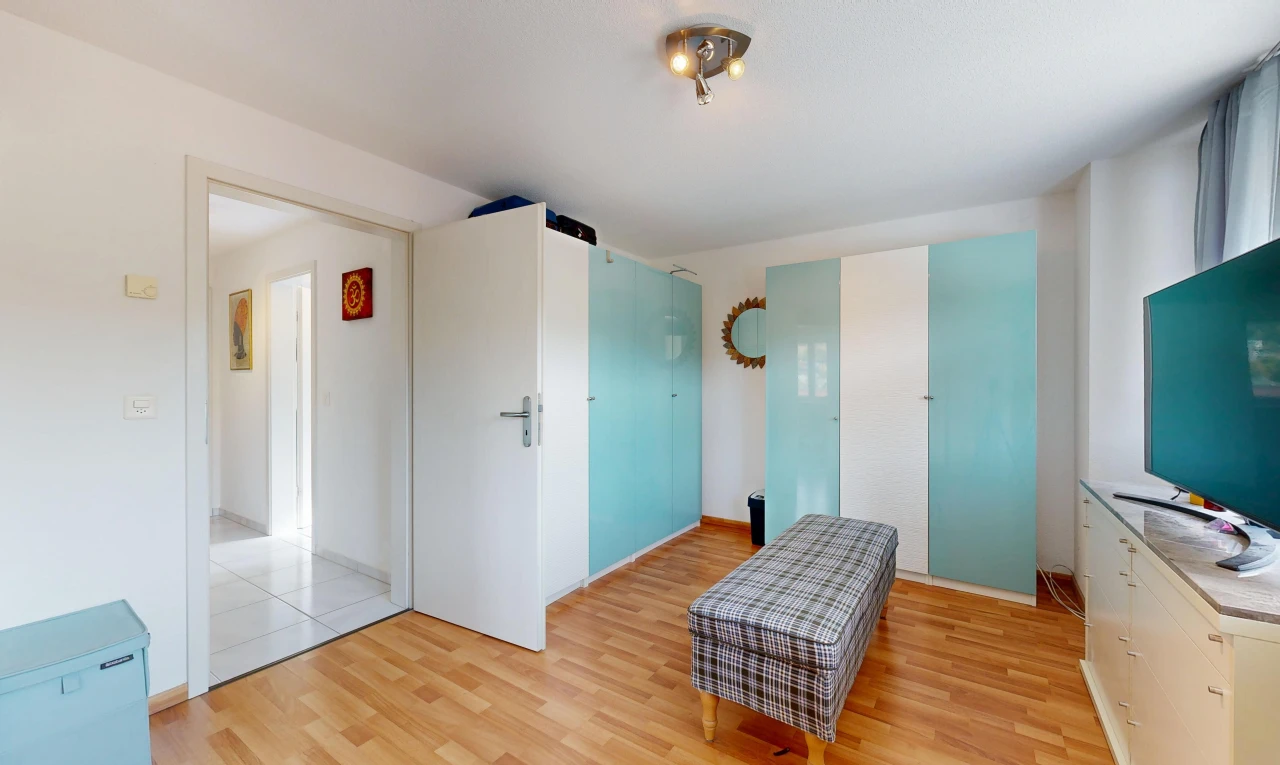 chambre avec cloison sèche, drywall, light floor, sol en finition bois, et wood finish floor