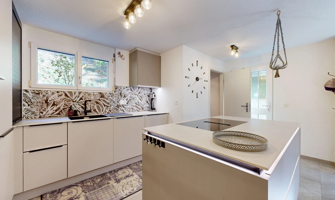 cuisine avec plans de travail, light countertops, îlot de cuisine, kitchen island, et évier