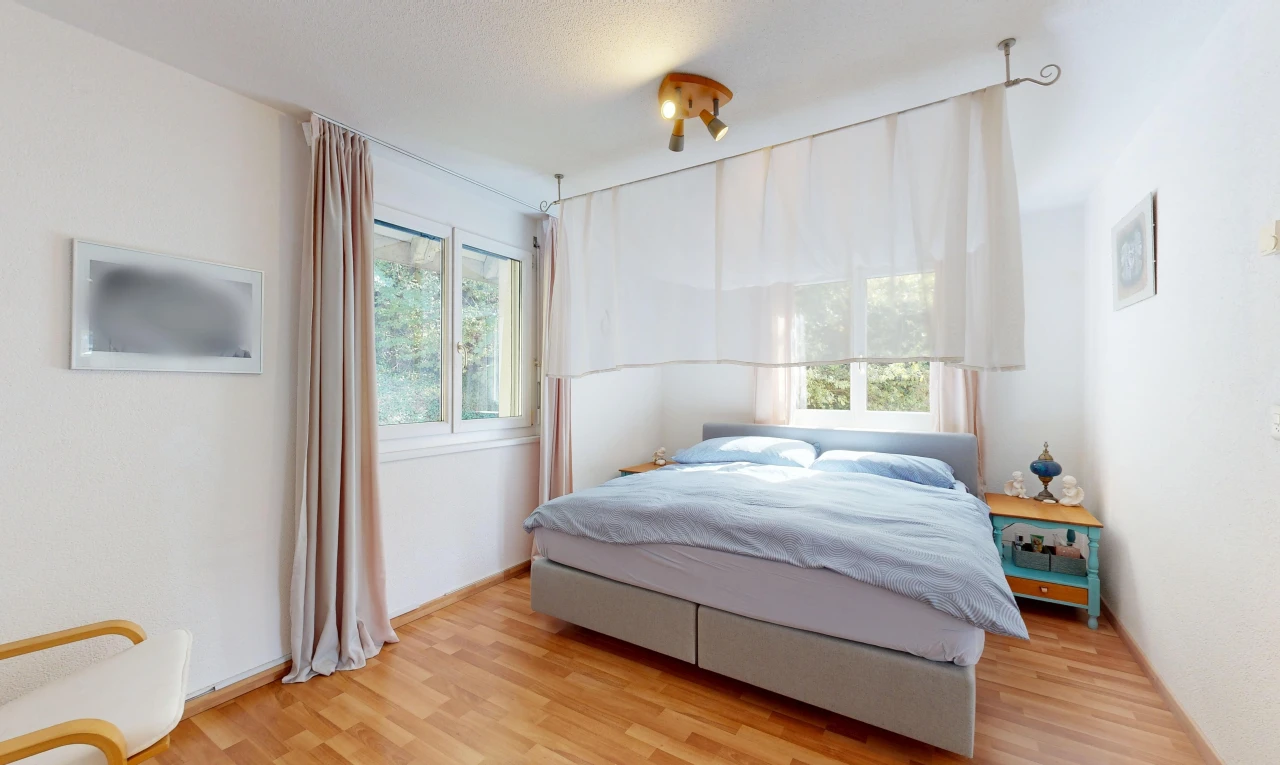 chambre avec cloison sèche, drywall, lumière naturelle, sol en finition bois, et wood finish floor