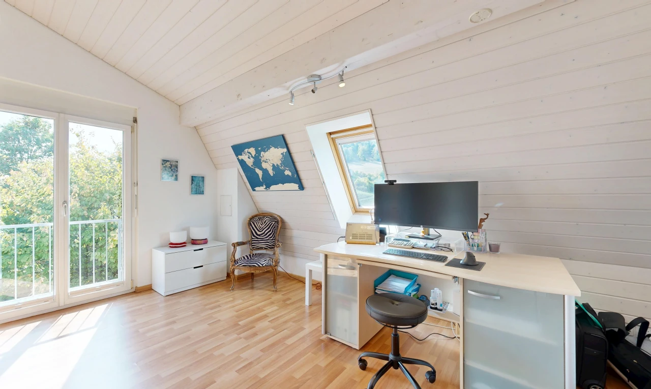 bureau avec plafond voûté, vaulted ceiling, télévision, sol en finition bois, et wood finish floor