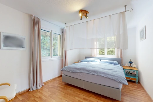 chambre avec cloison sèche, drywall, lumière naturelle, sol en finition bois, et wood finish floor