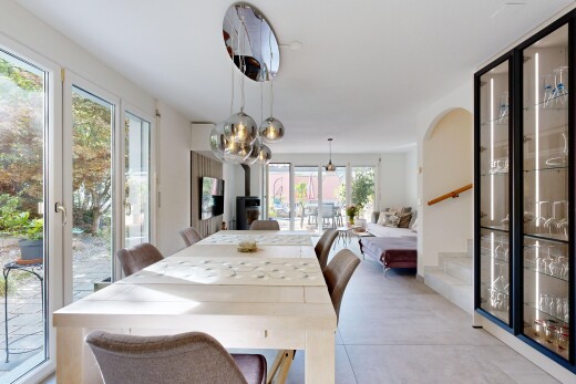 salle à manger avec escaliers, accès à l'extérieur, éclairage suspendu, télévision, et light floor
