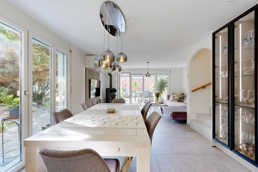 salle à manger avec escaliers, accès à l'extérieur, éclairage suspendu, télévision, et light floor