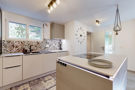 cuisine avec plans de travail, light countertops, îlot de cuisine, kitchen island, et évier