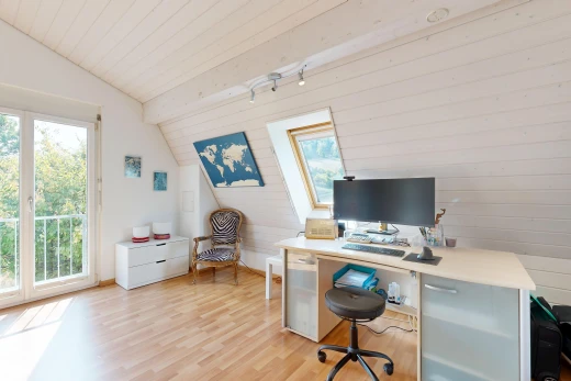 bureau avec plafond voûté, vaulted ceiling, télévision, sol en finition bois, et wood finish floor