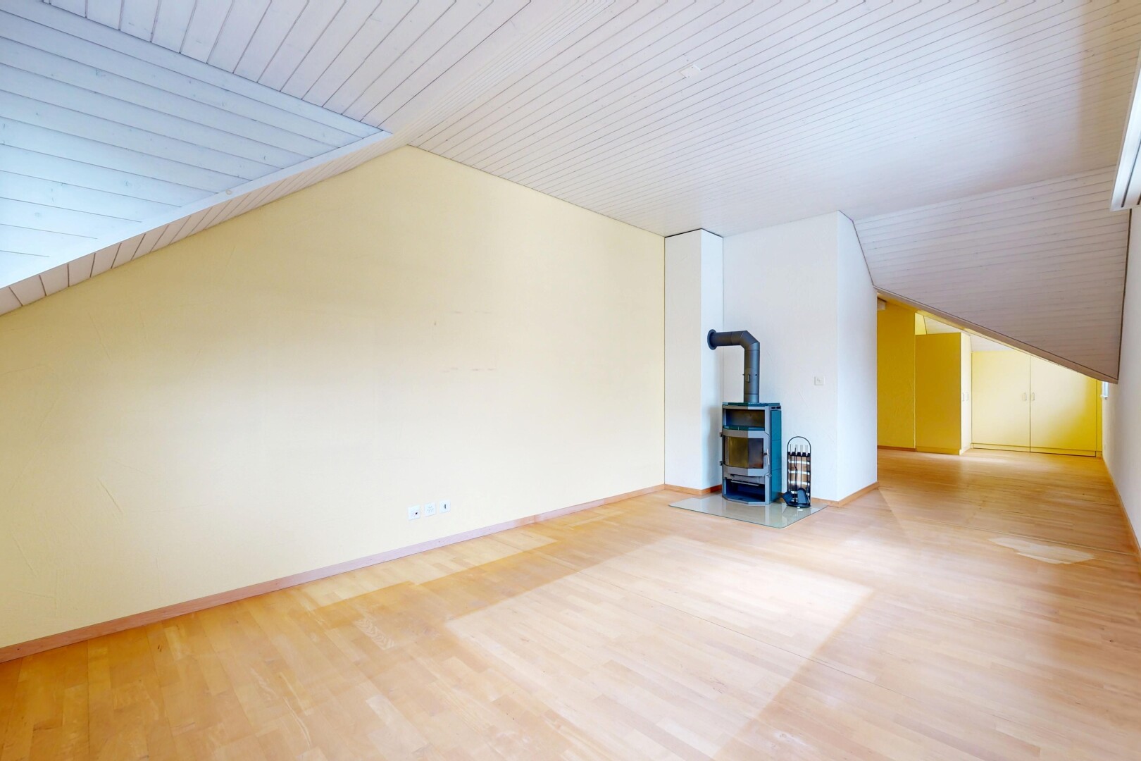 leerer raum mit holzofen, wood finish floor, holzfußboden, vaulted ceiling, und dachschräge