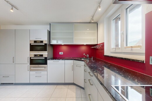 cuisine avec track lighting, éclairage sur rail, dark countertops, light floor, et stone countertops