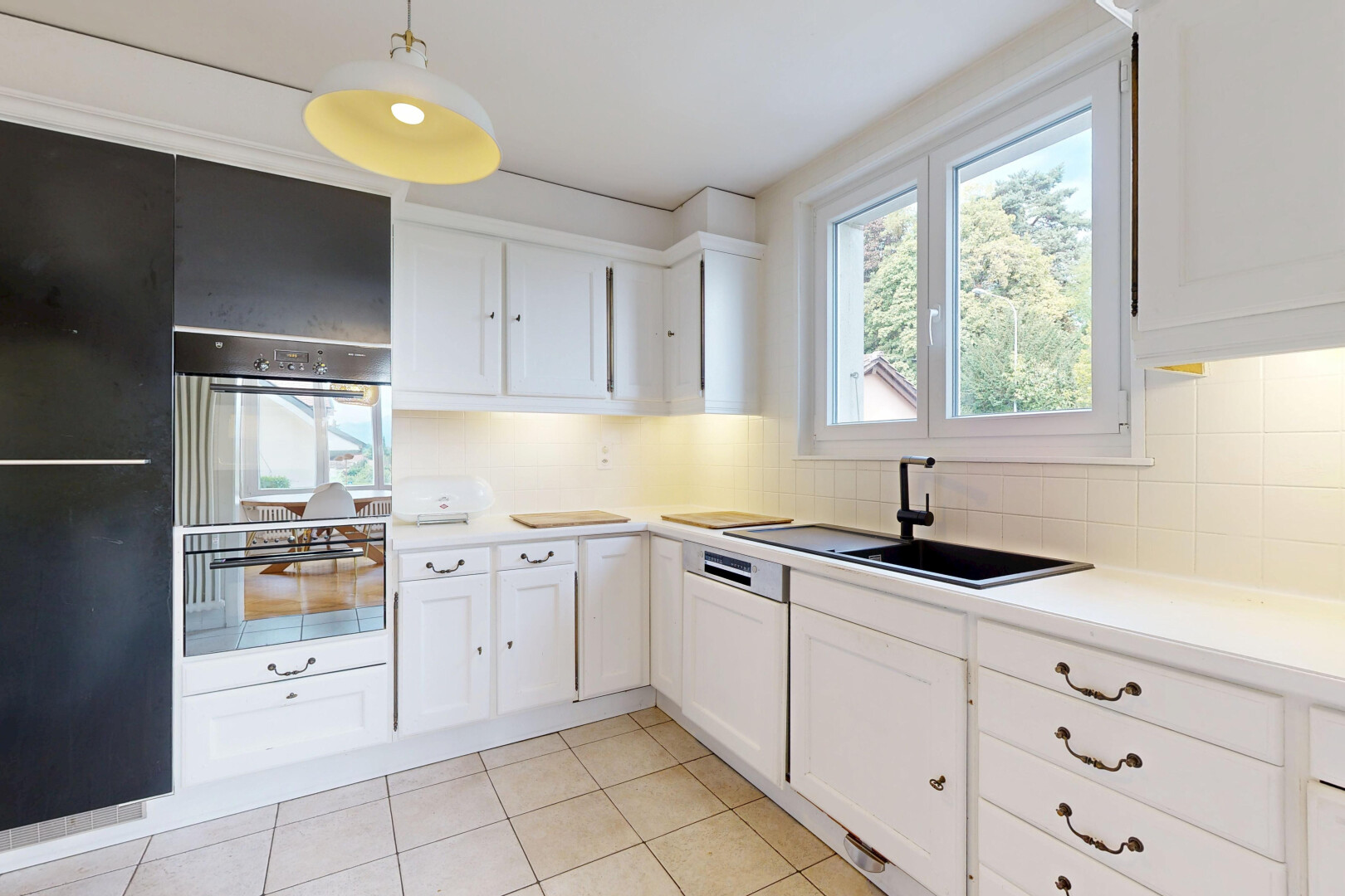 cuisine avec white cabinets, armoires blanches, éclairage suspendu, light floor, et four