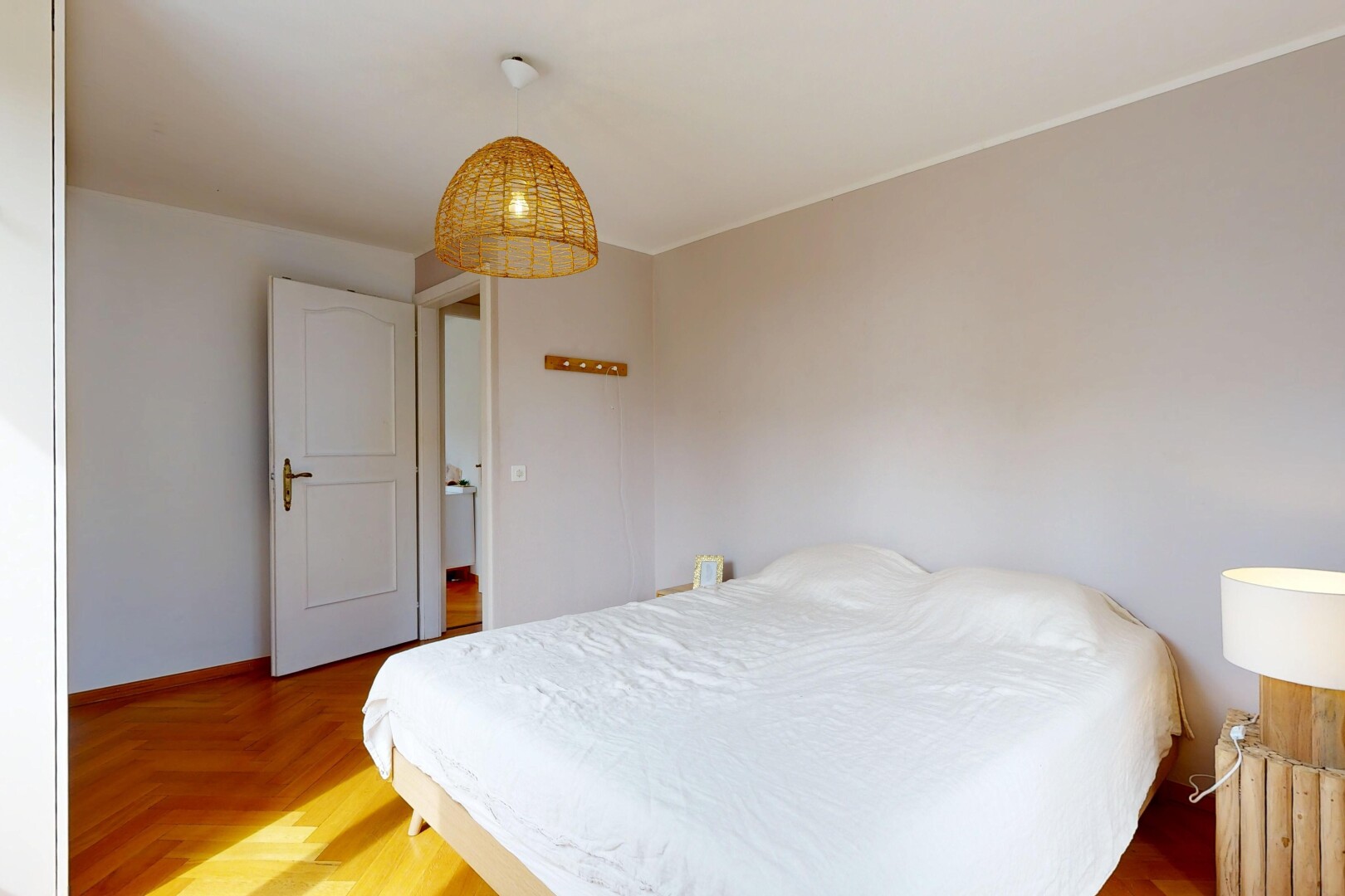 chambre avec éclairage suspendu, wood finish floor, sol en finition bois, drywall, et cloison sèche