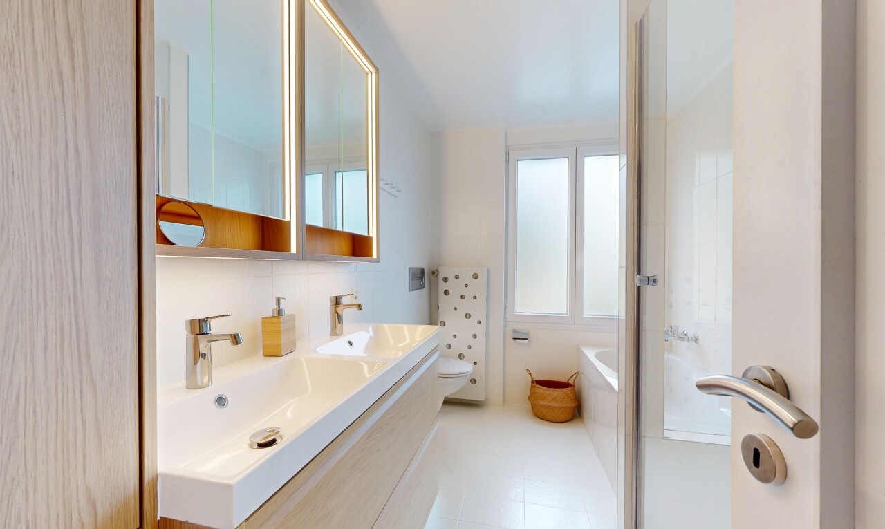 salle de bains avec salle de bain complète, miroir, double vasque, bain, et évier