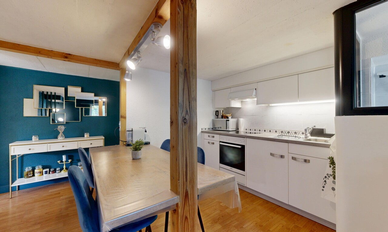 cuisine avec wood finish floor, sol en finition bois, white cabinets, armoires blanches, et hotte