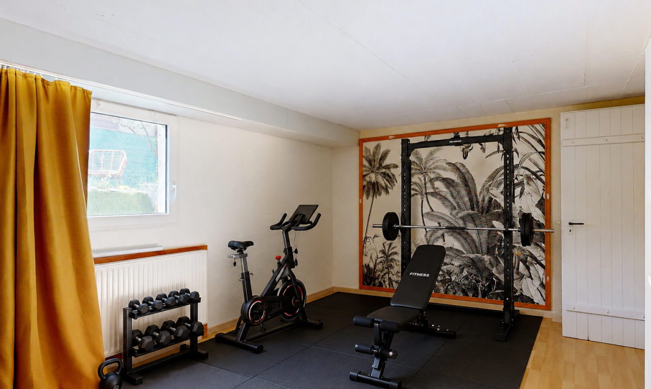 gym avec drywall, cloison sèche, lumière naturelle, radiateur, et wood finish floor