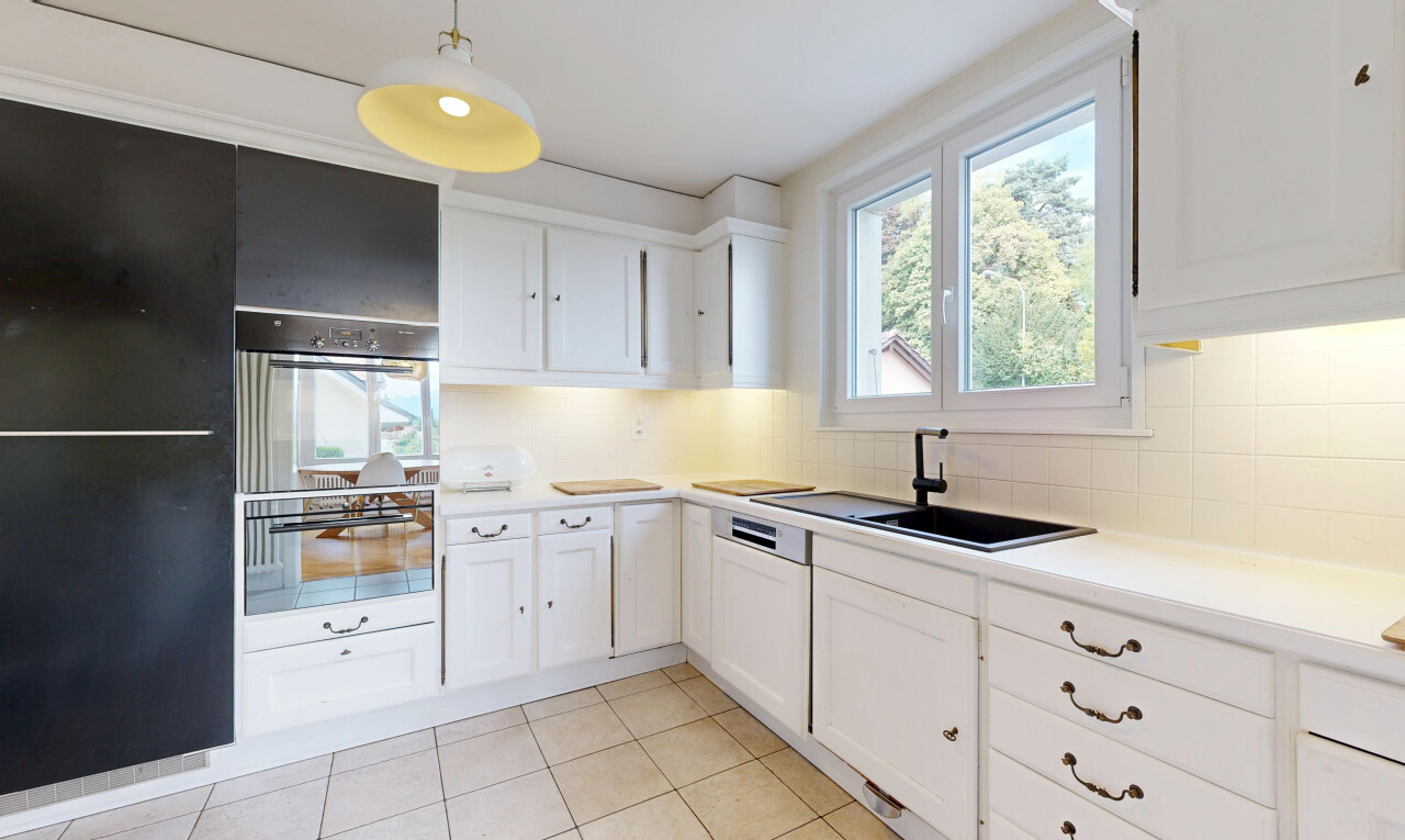 cuisine avec white cabinets, armoires blanches, éclairage suspendu, light floor, et four
