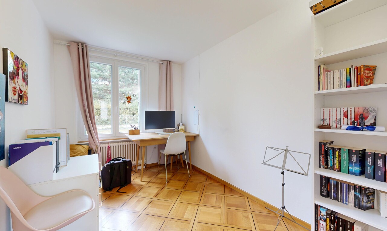 bureau avec cloison sèche, drywall, télévision, radiateur, et sol en finition bois