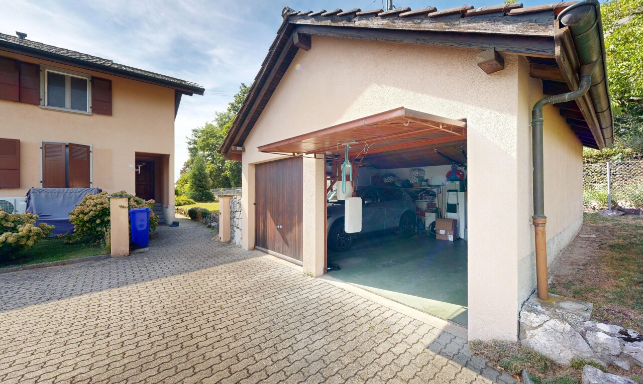 façade avec garage, property visible, bardage en stuc, allée, et day time