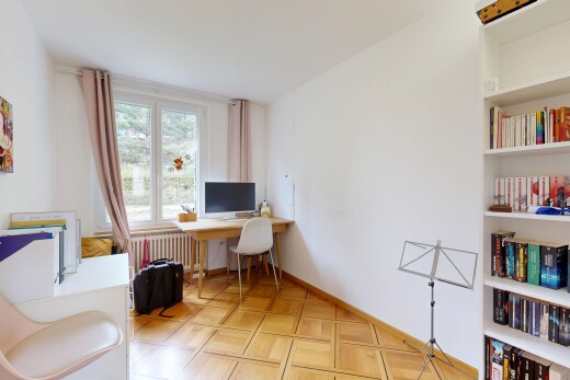 bureau avec cloison sèche, drywall, télévision, radiateur, et sol en finition bois