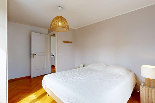 chambre avec éclairage suspendu, wood finish floor, sol en finition bois, drywall, et cloison sèche