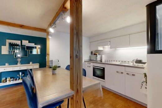 cuisine avec wood finish floor, sol en finition bois, white cabinets, armoires blanches, et hotte