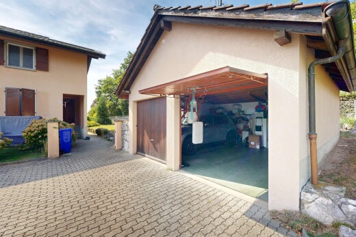 façade avec garage, property visible, bardage en stuc, allée, et day time