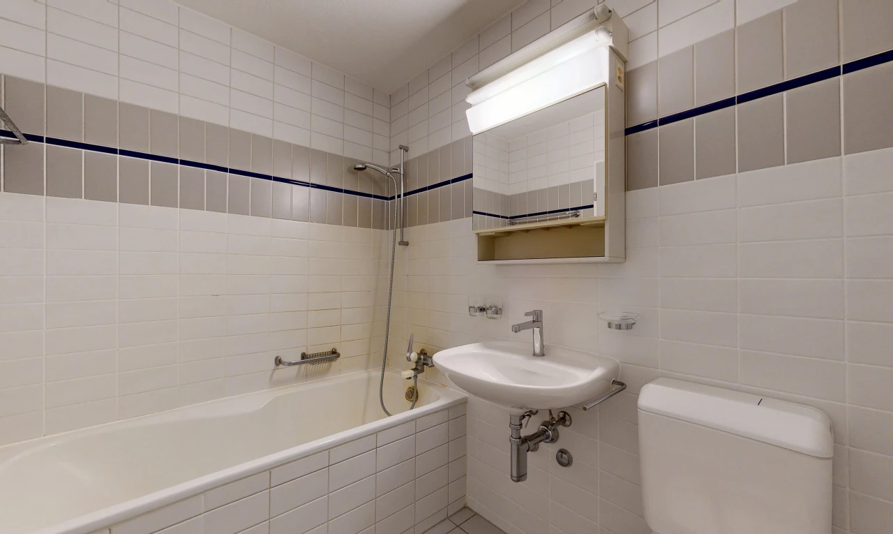 full bath with tile walls and tiled shower / bath