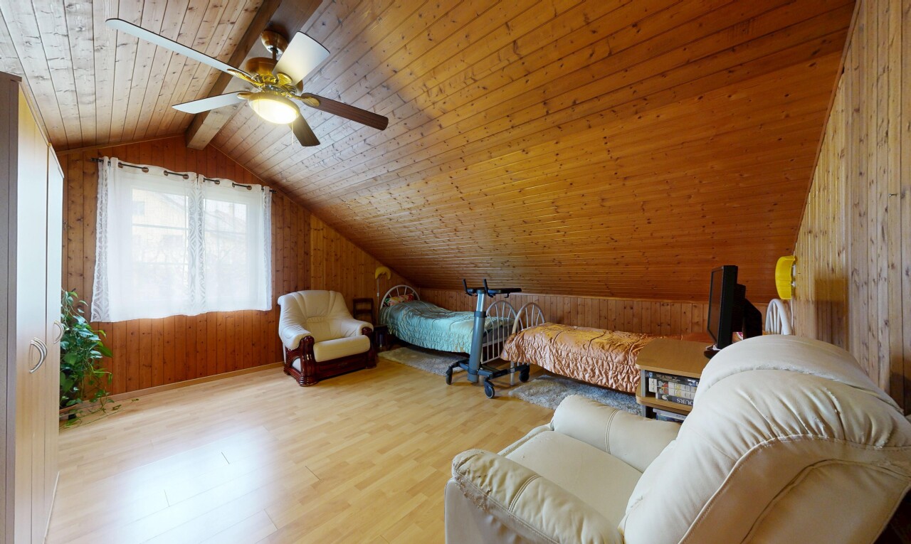 wohnzimmer mit zusätzliches zimmer, dachschräge, vaulted ceiling, holzwand, und wood wall