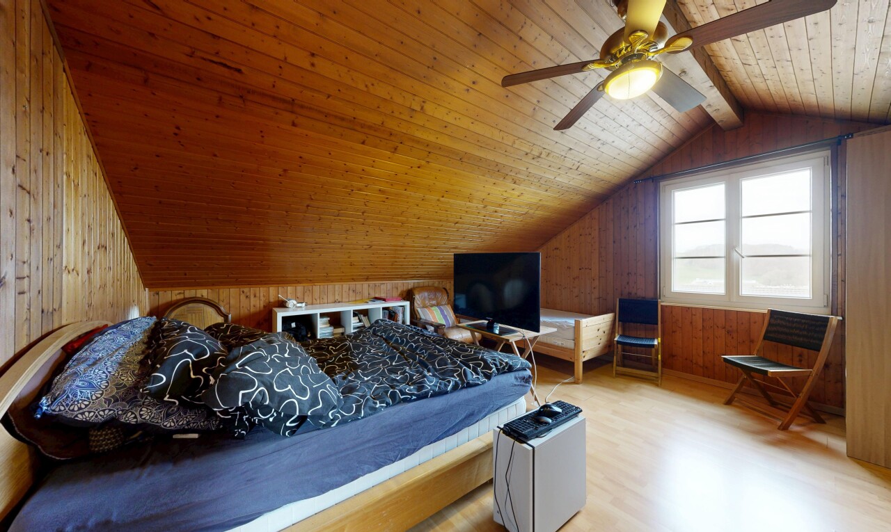zimmer / schlafzimmer mit zusätzliches zimmer, vaulted ceiling, dachschräge, fernseher, und wood finish floor