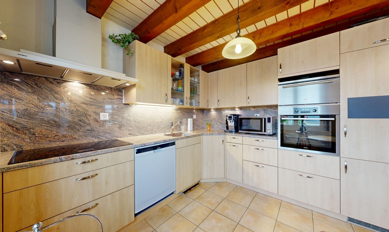 küche mit dunstabzugshaube, hellbraune schränke, light brown cabinets, ofen, und küchenrückwand beim herd