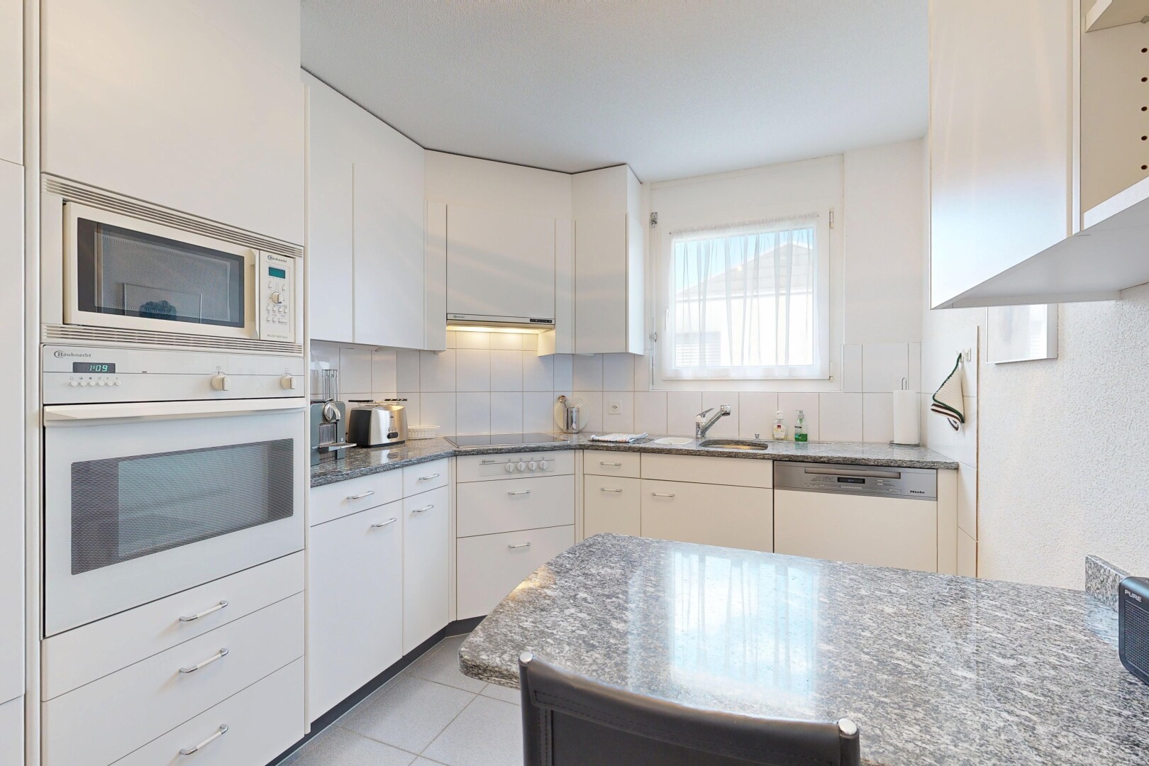 cuisine avec four, micro-ondes, natural light, lumière naturelle, et backsplash