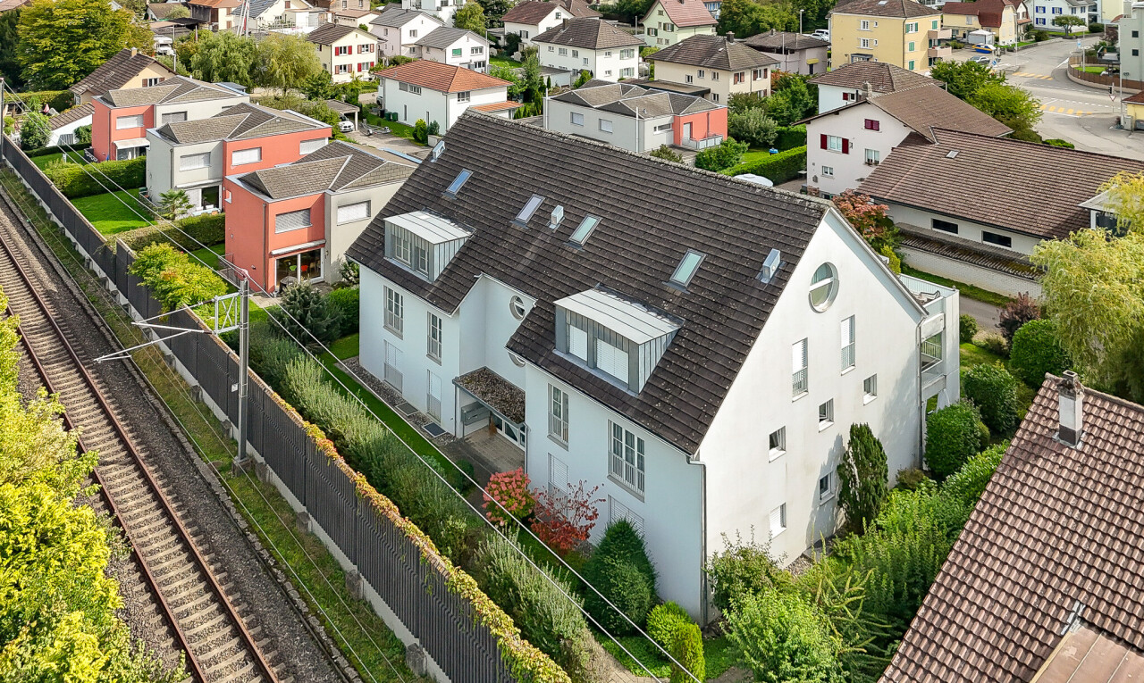 façade avec clôture, drone view, power lines view, bardage en stuc, et toit mansardé
