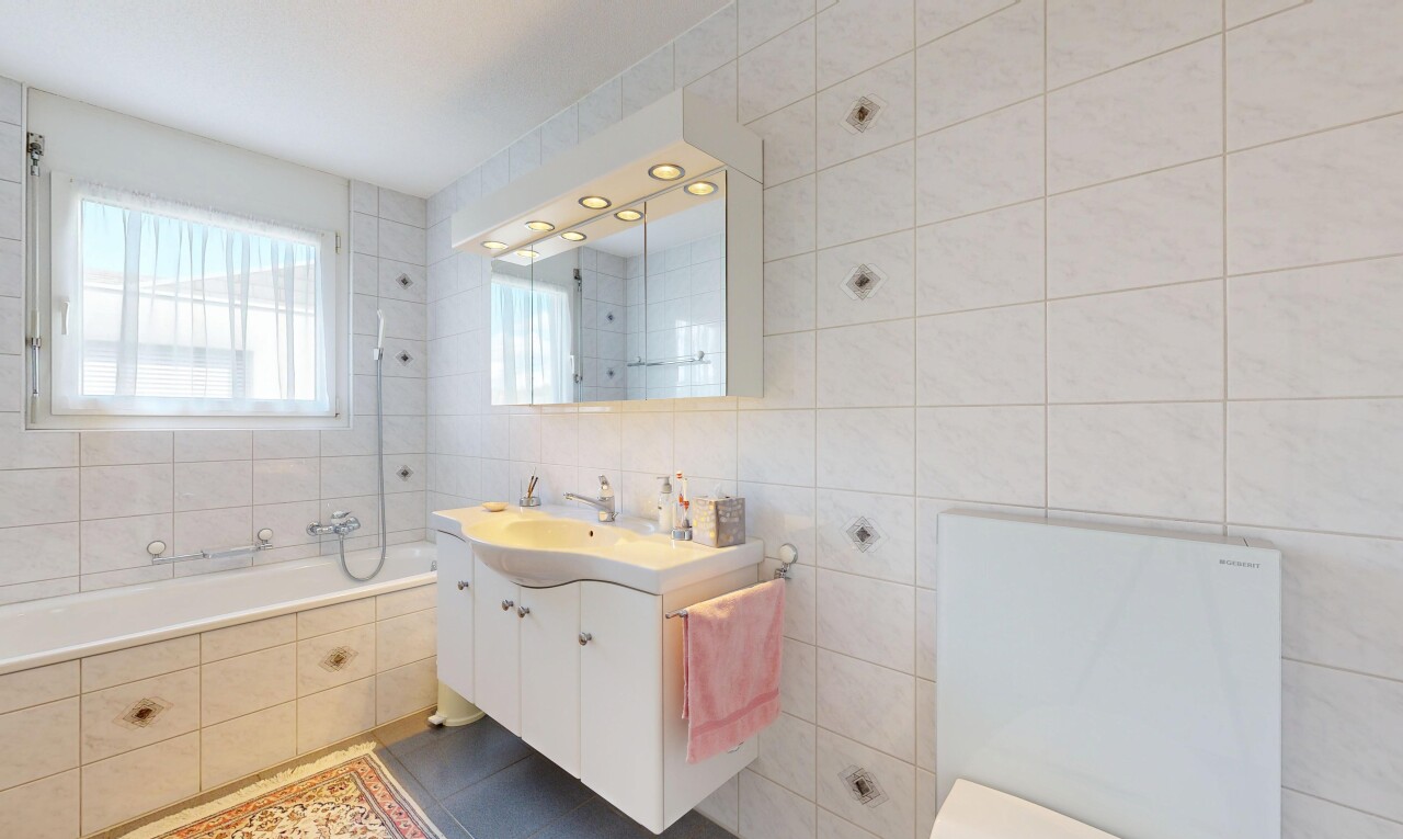 salle de bains avec mur en carrelage, tile wall, lavabo (ou coiffeuse selon le contexte), salle de bain complète, et miroir