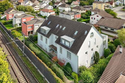 façade avec clôture, drone view, power lines view, bardage en stuc, et toit mansardé