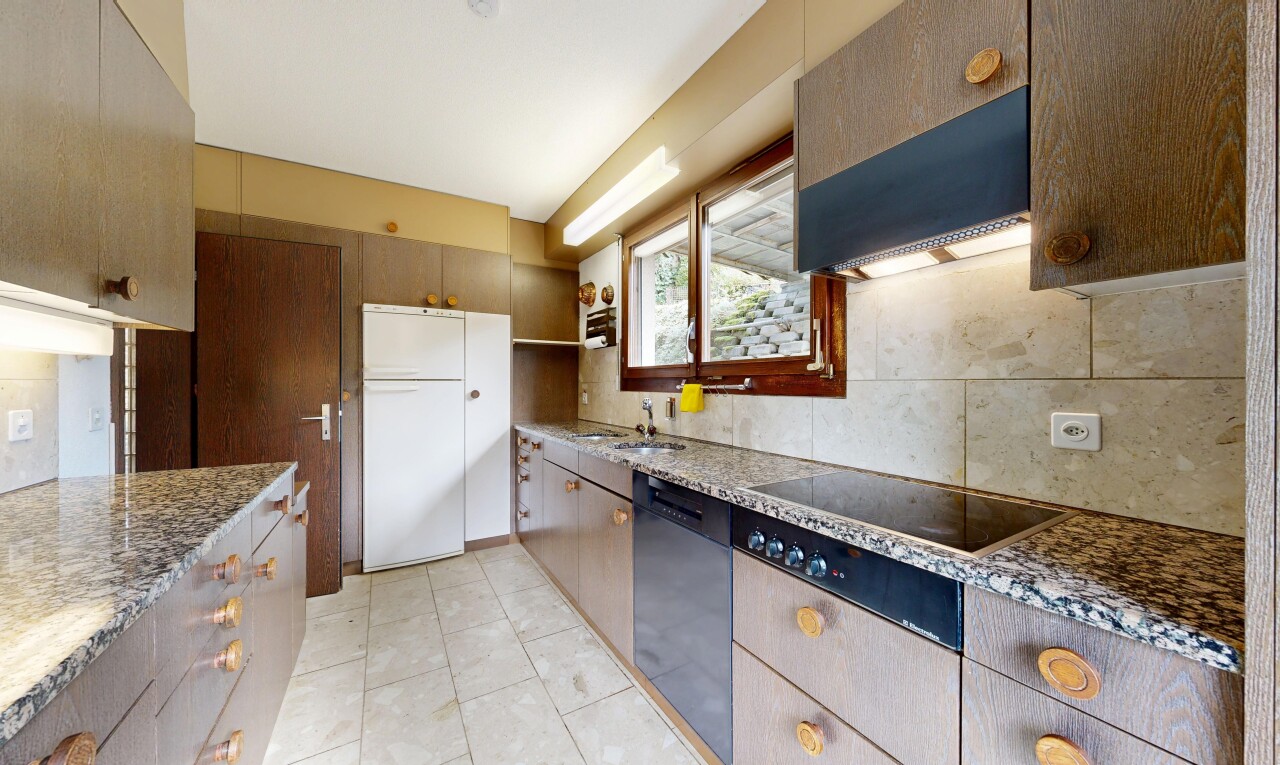 cuisine avec hotte, backsplash, dosseret, plans de travail en pierre, et natural light