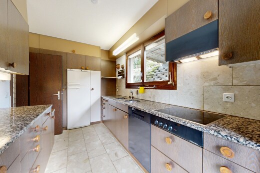 cuisine avec hotte, backsplash, dosseret, plans de travail en pierre, et natural light