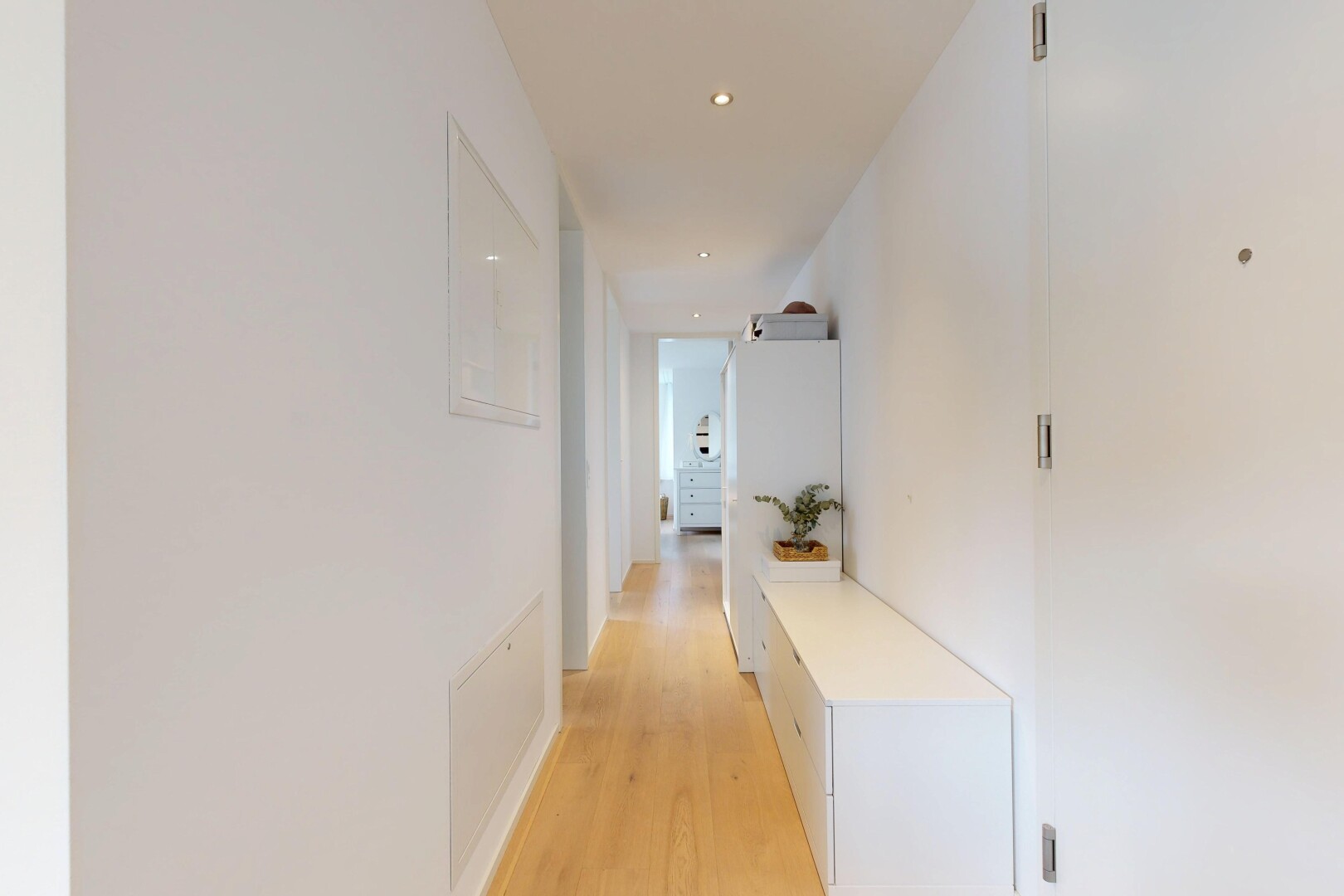 couloir avec wood finish floor, sol en finition bois, éclairage encastré, drywall, et cloison sèche