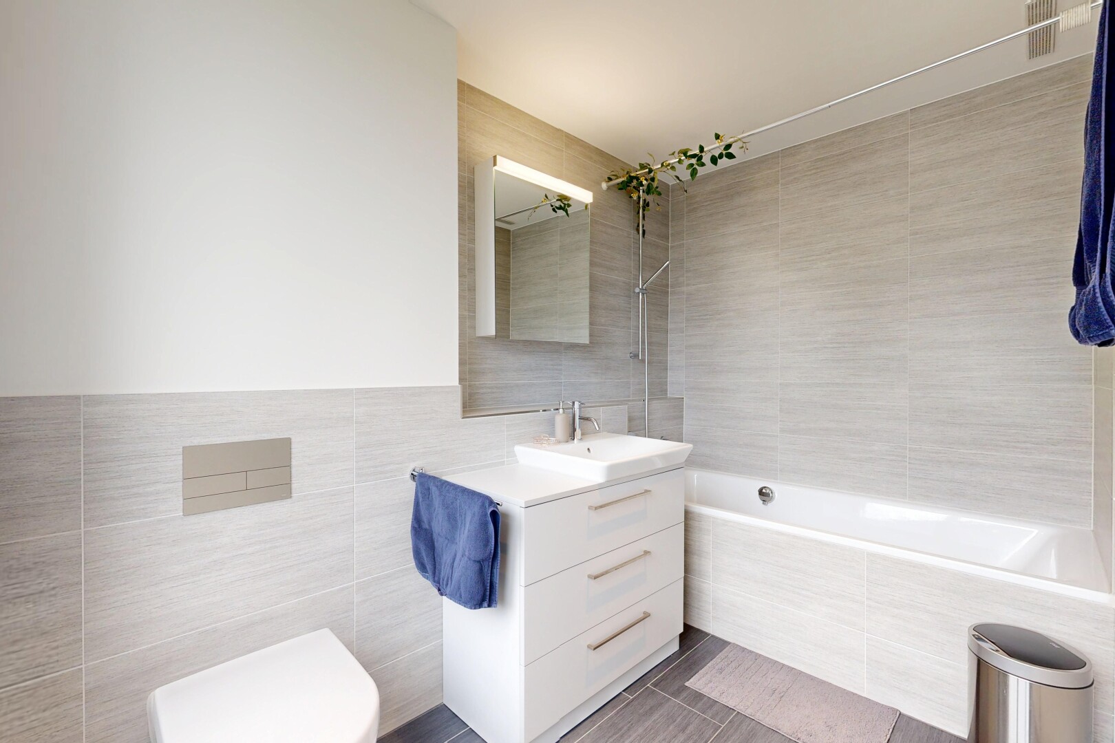 salle de bains avec tile wall, mur en carrelage, salle de bain complète, lavabo (ou coiffeuse selon le contexte), et miroir