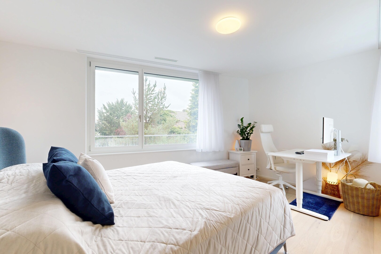 chambre avec espace bureau, wood finish floor, sol en finition bois, drywall, et cloison sèche