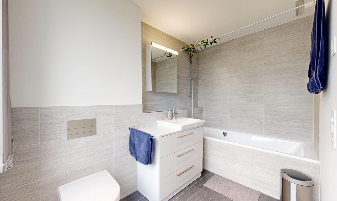 salle de bains avec tile wall, mur en carrelage, salle de bain complète, lavabo (ou coiffeuse selon le contexte), et miroir