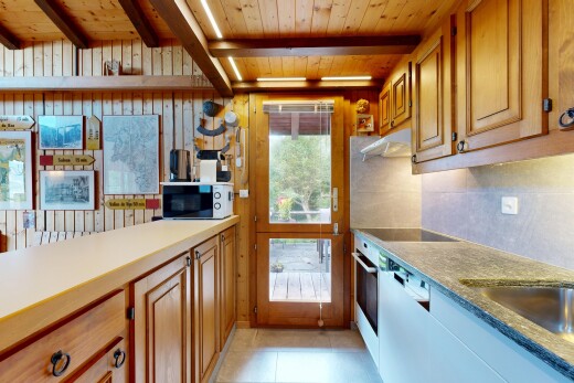 cuisine avec armoires élevées, armoires à charnières visibles, inside property, plafond à poutres, et beamed ceiling