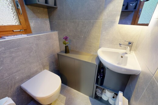 salle de bains avec mur en carrelage, tile wall, toilette, miroir, et inside property